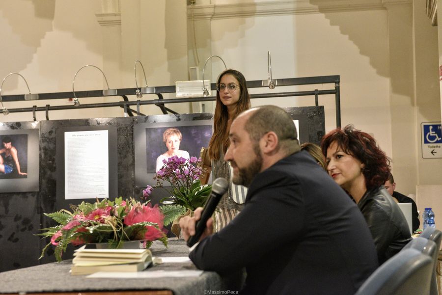 Ospiti della mostra conversano davanti alle fotografie esposte
