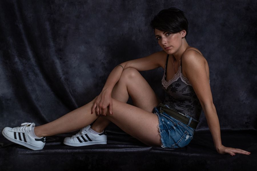 Ritratto in studio di una partecipante al progetto, seduta e sorridente